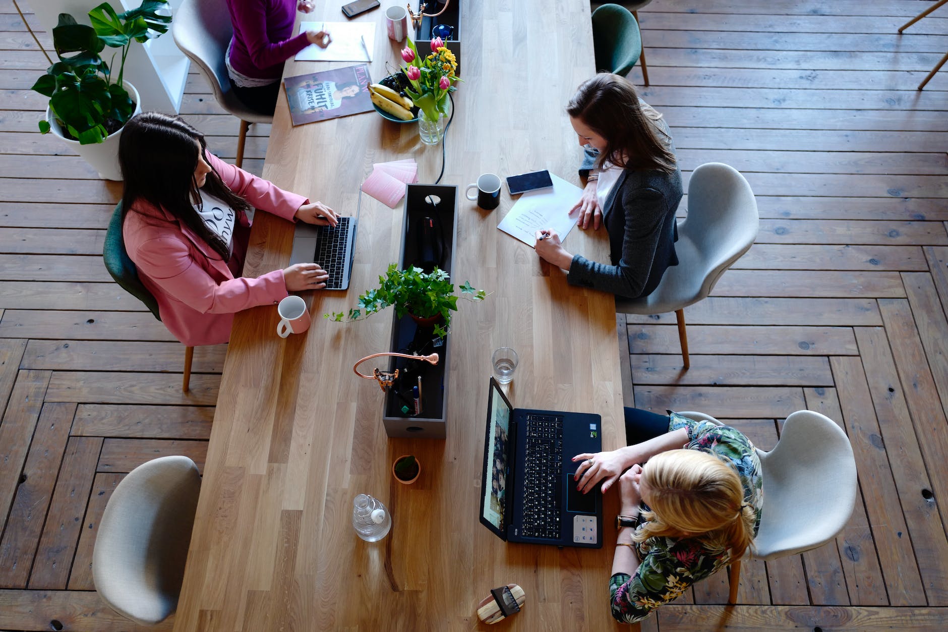 three woman sitting on white chair in front of table